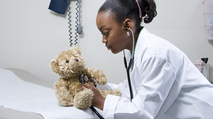 Girl Giving Teddy Bear a Checkup - Savannah Children's Heart Pediatric Cardiologists